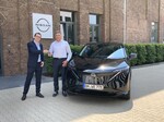 Vincent Ricoux (l.), Geschäftsführer von Nissan Deutschland, übergibt Bürgermeister Ralph Manzke den neuen Dienstwagen, einen Ariya.